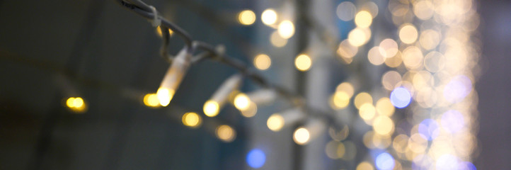 Fototapeta premium blurred glowing lights of garlands of golden color, bokeh. banner