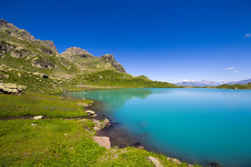Fototapeta na wymiar Alpine mountain lake at the daytime, sunlight and colorful landscape