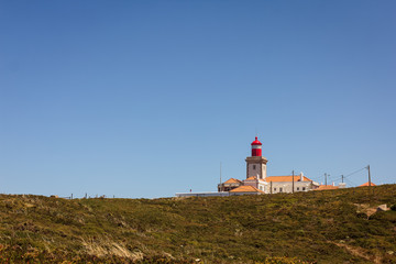 Fototapeta na wymiar View of Cabo da Roca, Sintra, Portugal, the westernmost point of continental Europe, with its famous lighthouse, surrounded by greenery on a bright summer sunny day