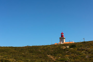 Fototapeta na wymiar View of Cabo da Roca, Sintra, Portugal, the westernmost point of continental Europe, with its famous lighthouse, surrounded by greenery on a bright summer sunny day