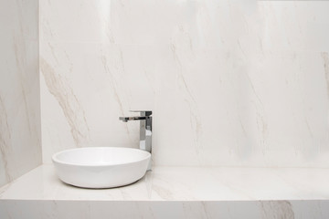 Naklejka na ściany i meble Lavabo con mezcladora en un baño con acabados de marmol