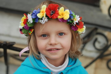 Small girl in ukrainian wreath with colorful ribbons