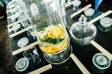 lemonade dispenser with mint and lemon and orange wedges