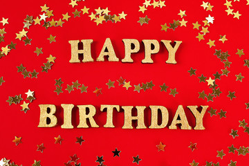 Text Happy birthday laid out of gold letters on beautiful background. Golden stars confetti.