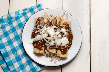 Mexican chicken enchiladas with mole sauce on white background