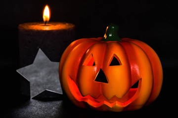 halloween! Bright yellow pumpkin on a black background with a black candle
