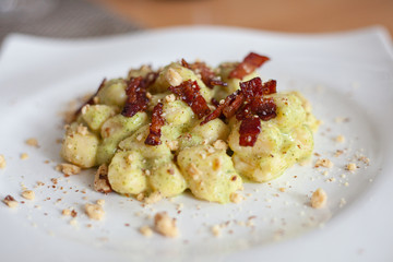 Still life cibo, piatti da ristorante. Food service e fotografie gustose di primi piatti fatti in casa, gnocchi handmade pancetta, guanciale, pistacchio e pan grattato.