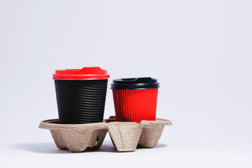 Two disposable coffee cups in cardboard holder. Isolated on a white.