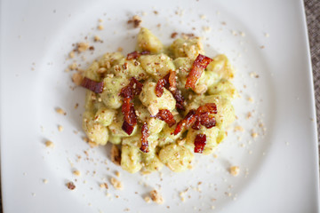 Still life cibo, piatti da ristorante. Food service e fotografie gustose di primi piatti fatti in casa, gnocchi handmade pancetta, guanciale, pistacchio e pan grattato.