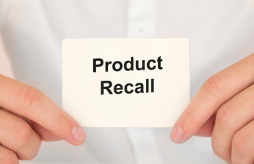 Man's hands take a card with words Product recall, finance and business concept.