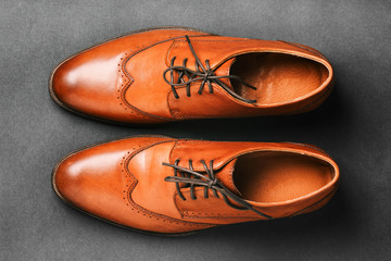 Pair of brown shoes on a black background. Men's fashion shoes. Classic men's shoes made of genuine leather. Men's accessories. Elegant stylish shoes