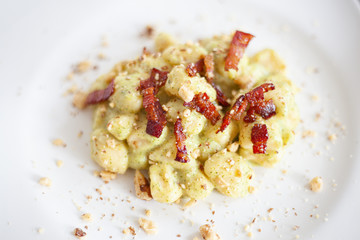 Still life cibo, piatti da ristorante. Food service e fotografie gustose di primi piatti fatti in casa, gnocchi handmade pancetta, guanciale, pistacchio e pan grattato.