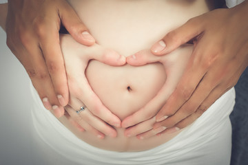 Fototapeta na wymiar pregnancy, woman, belly, baby, love, mother, heart, body, abdomen, stomach, hands, hand, human, beauty, white, maternity, family, life, care, expecting, birth, motherhood, young, beautiful, holding