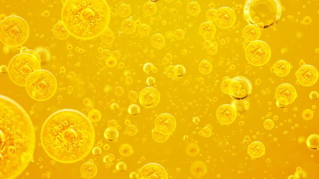 Through the bubbles. Motion. Oil background. Golden liquid with air bubbles  for projects, oil, honey, beer, juice, shampoos