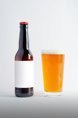 Beer Bottle Mock-Up with glass of pale ale and foam. Blank Label.