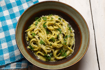 Creamy green pasta with poblano pepper and parmesan cheese on white background