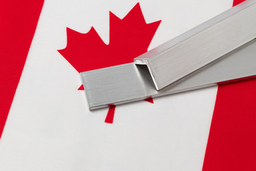 Aluminum metal stock on flag of Canada. Concept of trade war, tariffs, fair trade and steel...