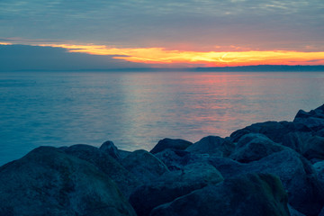 Sunset over the sea between the rocks