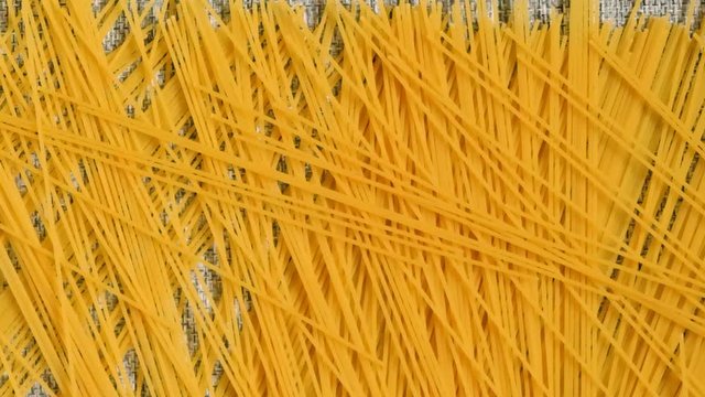 The spaghetti has fallen on the grey background and is crumbling. 