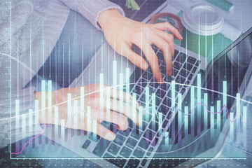 Double exposure of woman hands typing on computer and forex chart hologram drawing. Stock market invest concept.