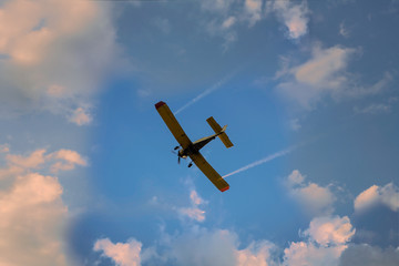 the airplane flying in the clouds in the beautiful sky