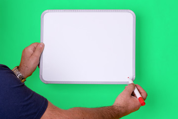 man in black shirt holding a blank board on green background