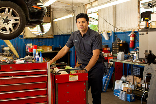 Portrait of Hispanic car mechanic working in auto shop.