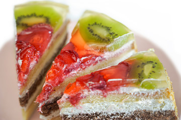 a piece of puff pastry cake with strawberries and kiwi is on a plate