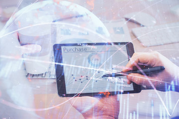 Double exposure of man's hands holding and using a phone and financial chart drawing. Market analysis concept.