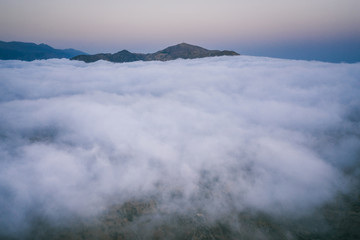 Fototapeta na wymiar Sunset over the clouds and rugged south coast of Crete