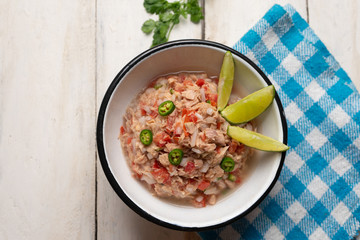 Canned tuna ceviche with chili pepper and tomato on white background