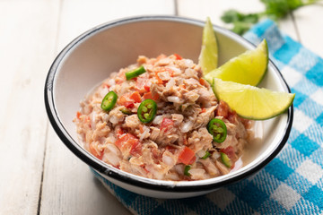 Canned tuna ceviche with chili pepper and tomato on white background