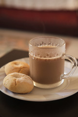 Cookies and coffee in a white plate. Coffee with milk in glass cup. Homemade cookies.