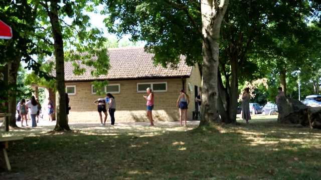 Blurred view of women queue outside of public toilet keeping 2 metre distance, some wearing protective face masks due to coronavirus pandemic.