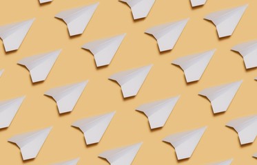 Set of paper planes on yellow paper. Lots of white paper planes on a yellow background.