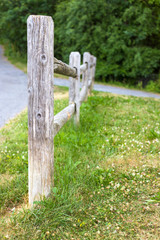 Old wooden fence near the road in the park 