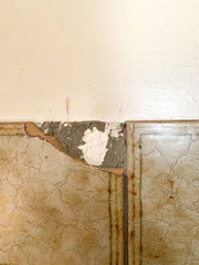 Damaged vintage tile corner on the wall inside old house