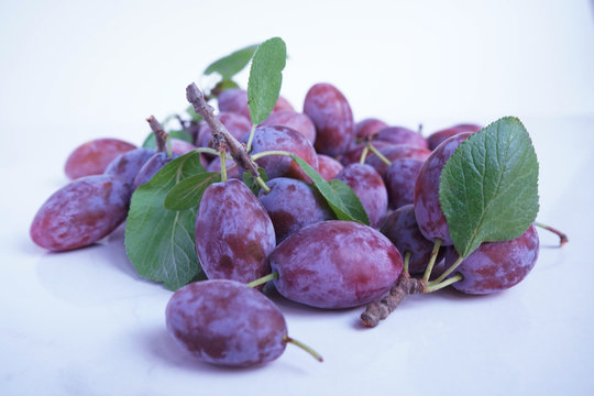 Macro photo food fruit plum on a white background. Texture background of fresh blue plums. Pictures fruit food blue plums.