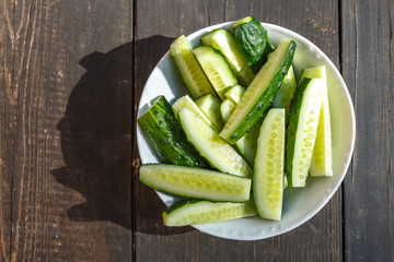 Sliced fresh cucumbers in a plate on a wooden Board