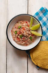 Canned tuna ceviche with chili pepper and tomato on white background