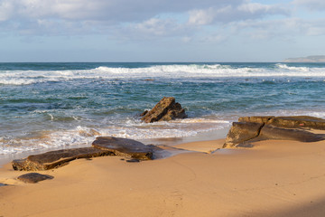 Rock formation on the sand at beach coastline.