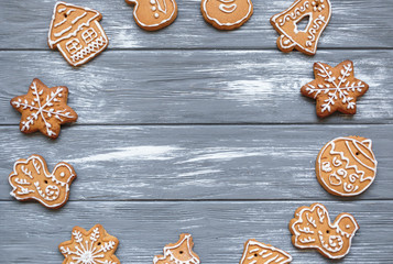 Homemade christmas gingerbread cookies on gray wooden background. Snowflake, star, tree, snowman, deer shapes. Holiday, celebration and cooking concept. Close up.