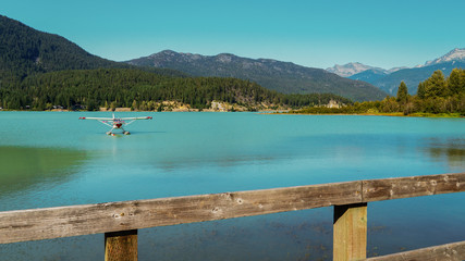 Float plane at anchor on Green Lake with mountain backdrop, Whistler - summer