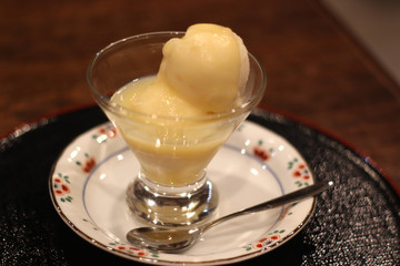Close up of a cup of Okayama peach sorbet on a plate served with a silver spoon, Okayama, Jaapan, soft focus