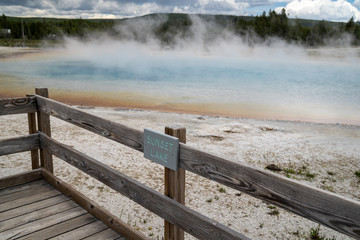Sunset Lake, a hot spring geyser in Black Sand Basin in Yellowstone National Park. Sign for the geothermal feature