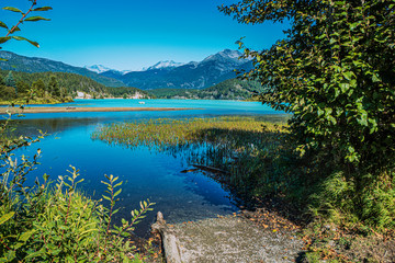 Fototapeta na wymiar Boat launch ramp at Green Lake BC with mountain backdrop on a perfect summer day