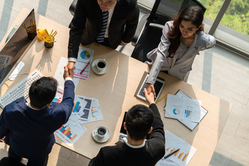 Group business people handshake at meeting table in office together with confident shot from top...