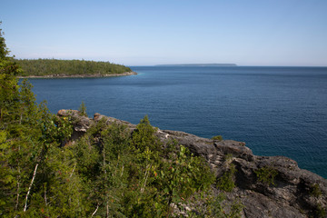 Fototapeta premium Blue water and rocky forested shoreline of georgian Bay along Bruce Peninsula trail