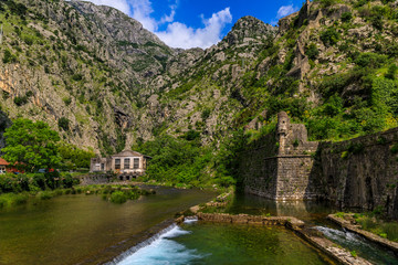 Fototapeta na wymiar Emerald green waters of Kotor Bay or Boka Kotorska and the ancient wall of Kotor former Venetian fortress in Montenegro