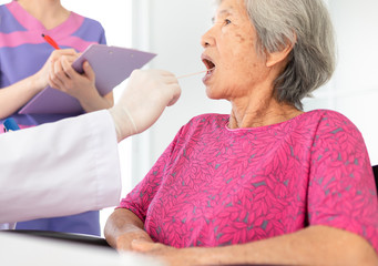 doctor use tongue depressor with old patient, he screening and diagnosis, elderly health check up